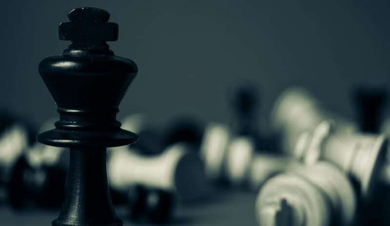 A dominant chess piece standing tall while all others are toppled, symbolizing the effectiveness of strategic rehab SEO.